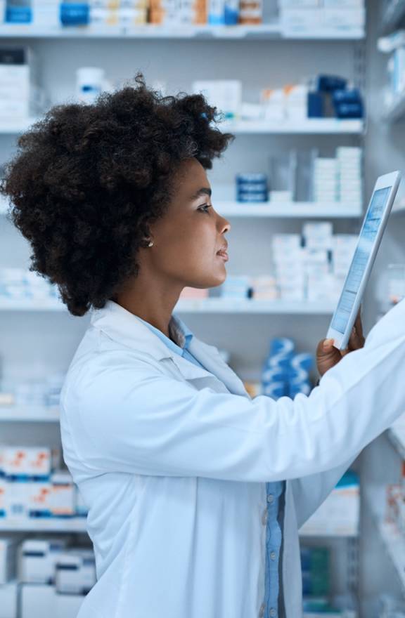 Pharmacist with tablet looking at supplies